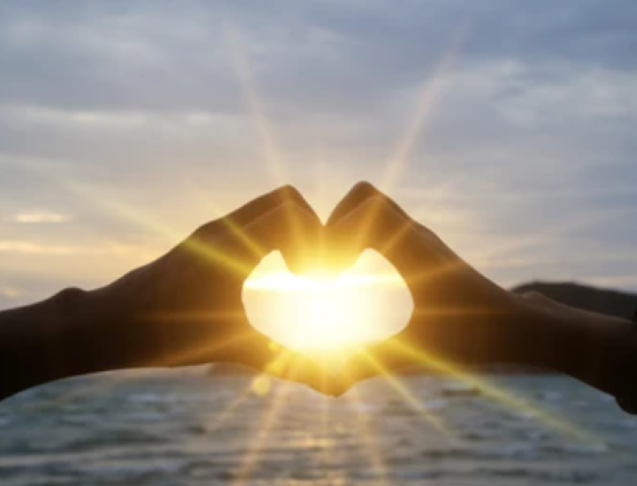 sunrise with hands in the shape of a heart