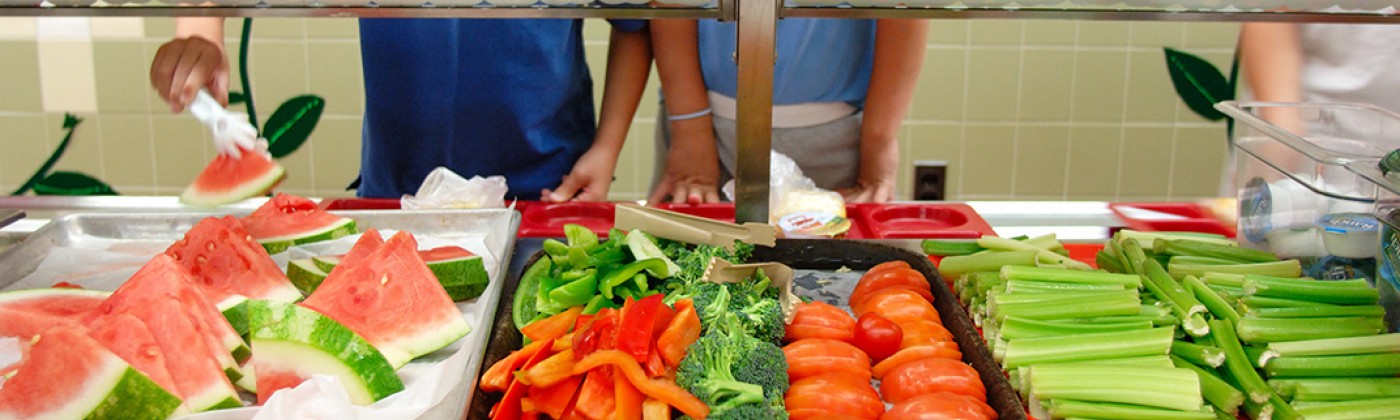 Children selecting fresh produce in a cafeteria line