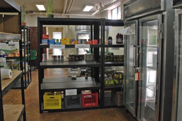 Shelves and glass-fronted refrigerators in a food pantry.