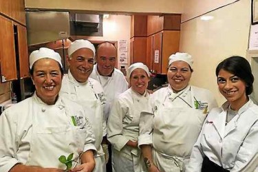 A line of chefs smiling and posing for the camera.